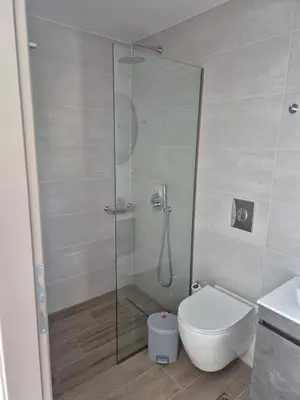 a bathroom with a shower with a toilet and a sink at Aldea Apartments in Palio Gerani