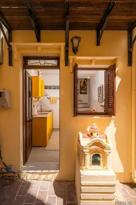 a kitchen with a yellow wall and a mirror at Romantic Maisonette in Chania Town