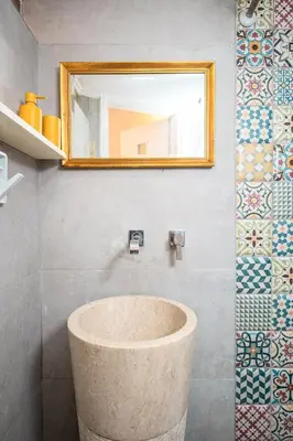 a bathroom with a stone sink and a mirror at Romantic Maisonette in Chania Town