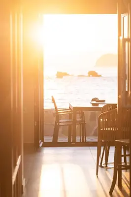 a dining room with a table and a view of the ocean at Paradise for Couples, Next to Soothing Waves in Galatás
