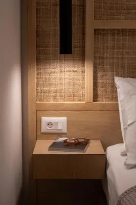 a pair of glasses on a table next to a bed at Paradise for Couples, Next to Soothing Waves in Galatás