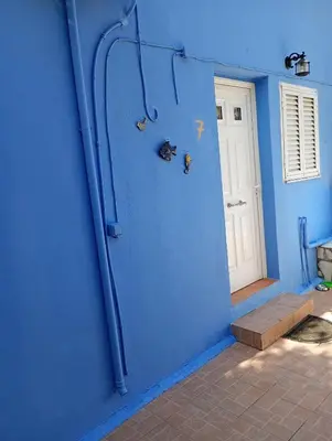 a blue wall with pipes on the side of a house at Stefanos Garden2 in Arménoi