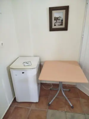 a wooden table next to a small white refrigerator at Stefanos Garden2 in Arménoi