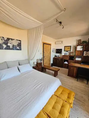 a bedroom with a large white bed and a desk at Cozy Room wtih Amazing Sea View of the Old Harbour in Chania Town