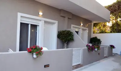 a white fence with flower pots on the side of a house at Tile apartments 1 in Agia Marina Nea Kydonias