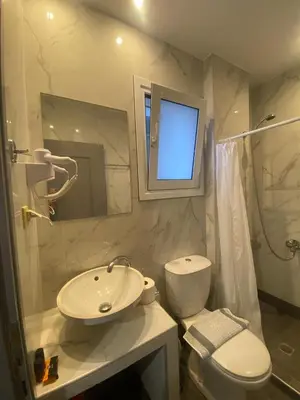a bathroom with a sink and a toilet and a window at Tile apartments 1 in Agia Marina Nea Kydonias
