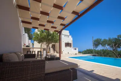 a patio with a view of a swimming pool at Villa Veghera in Kissamos
