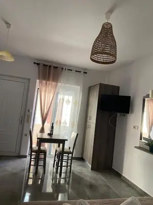 a dining room with a table and chairs and a television at Tile Apartments 2 in Agia Marina Nea Kydonias