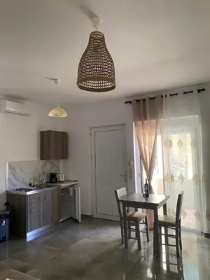 a kitchen with a table and chairs and a dining room at Tile Apartments 2 in Agia Marina Nea Kydonias