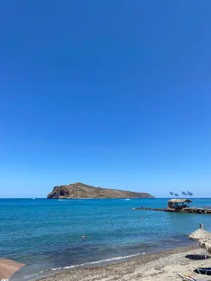 a beach with an island in the water at Tile Apartments 2 in Agia Marina Nea Kydonias