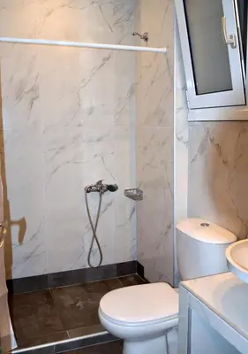 a bathroom with a shower with a toilet and a sink at Tile Apartments 2 in Agia Marina Nea Kydonias