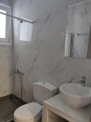 a white bathroom with a toilet and a sink at Tile Apartments 3 in Agia Marina Nea Kydonias