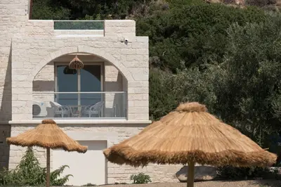 two straw umbrellas in front of a building at Libyan Mare in Palaiochóra