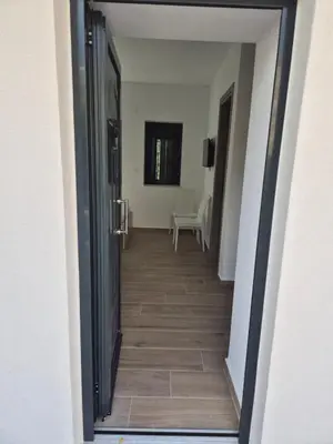 a hallway leading to a room with a table at Aldea Apartments in Palio Gerani