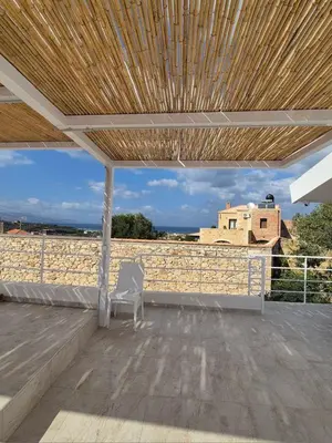 a white chair sitting on a patio with a wooden roof at Aldea Apartments in Palio Gerani