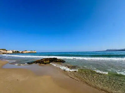 a beach with waves crashing on the shore at Mare suites 3 in Chania Town