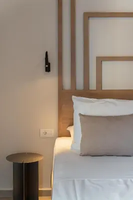 a bedroom with a bed with a wooden headboard and a table at Nea Chora Boutique Apartment in Chania Town