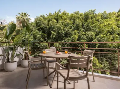 a table and chairs on a balcony with trees at Nea Chora Boutique Apartment in Chania Town