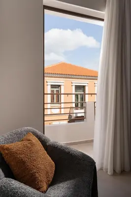 a living room with a couch and a large window at Nea Chora Boutique Apartment in Chania Town