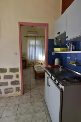 a kitchen with a sink and a stove top oven at Anonymous Homestay in Palaiochóra