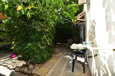 a chair sitting outside of a building next to a bush at Anonymous Homestay in Palaiochóra