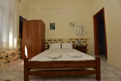 a bedroom with a bed and a wooden cabinet at Anonymous Homestay in Palaiochóra