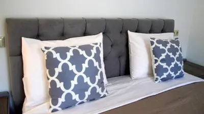 a bed with two pillows and a headboard at Tile Apartments 4 in Agia Marina Nea Kydonias