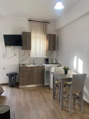 a kitchen with a table and a sink and a counter at Tile Apartments 4 in Agia Marina Nea Kydonias