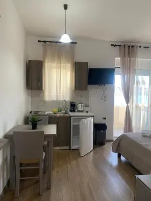 a kitchen with a table and a kitchen with a refrigerator at Tile Apartments 5 in Agia Marina Nea Kydonias
