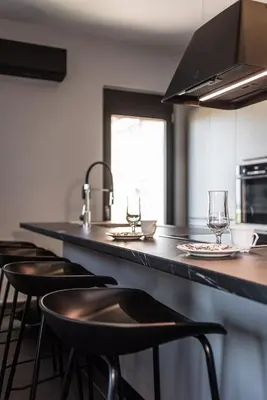 a kitchen with a counter with bar stools at Calmar Boutique Villa 5min drive to Kolymvari beach with Private Pool & Sea Views in Kolymvari
