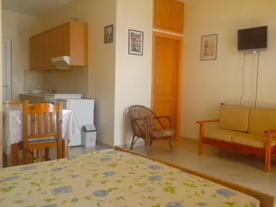 a room with a kitchen and a living room at Seaview Studio in beautiful setting, west from Chania in Ravdhoúkha