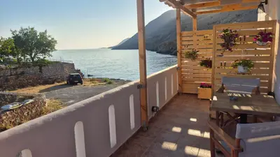 a balcony of a house with a view of the water at Sfakia On the Beach in Khóra Sfakíon