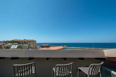 two chairs on a balcony with a view of the ocean at Pallazzo Dei Miracoli - Luxe 3BR apt Sea & Old Port Terrace View in Chania Town