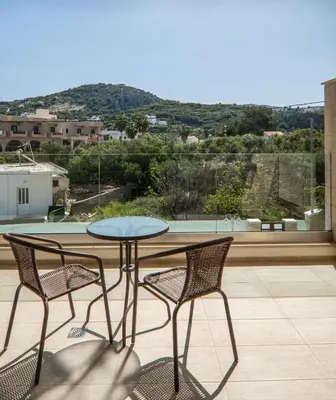a table and two chairs on a patio with a view at Altirina Studios in Almirida