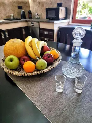 a basket of fruit on a table with a bottle at La Casa di Teta by superhosthub in Galatás