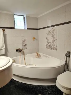 a white bathroom with a tub and a toilet at La Casa di Teta by superhosthub in Galatás