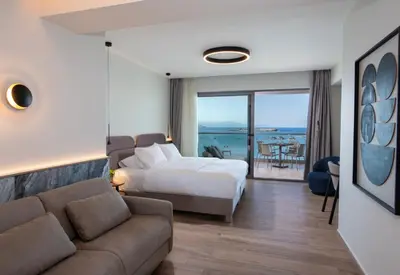 a hotel room with a bed and a couch at EdgeWater Beach Hotel in Chania Town