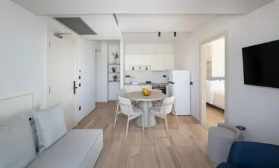 a kitchen and a dining room with a table and chairs at EdgeWater Beach Hotel in Chania Town