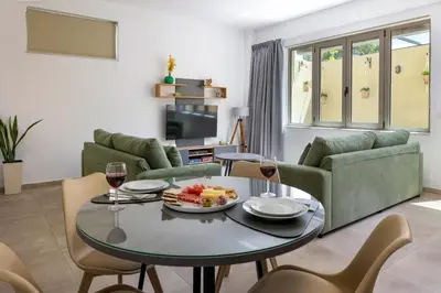 a living room with a table with glasses of wine at Cozy Light Nest Chania Crete in Kounoupidhianá
