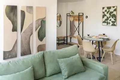 a living room with a green couch and a table at Cozy Light Nest Chania Crete in Kounoupidhianá