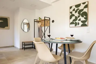 a dining room with a table and chairs at Cozy Light Nest Chania Crete in Kounoupidhianá