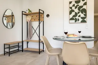 a dining room with a table and chairs and a mirror at Cozy Light Nest Chania Crete in Kounoupidhianá