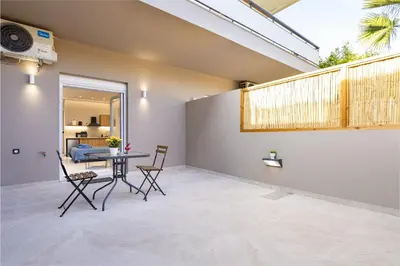 a patio with a table and chairs in a room at Dom Azure Studios in Agia Marina Nea Kydonias