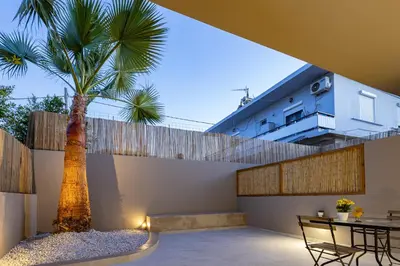 a palm tree in the courtyard of a house at Dom Azure Studios in Agia Marina Nea Kydonias