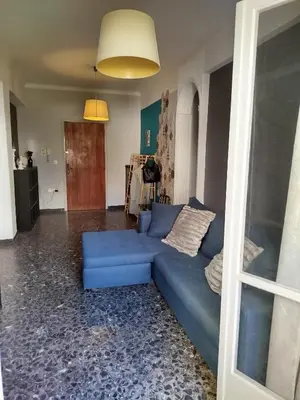 a living room with a blue couch in a room at Serenity Apartment Chania City Centre in Chania Town
