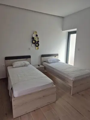 two beds in a white room with a window at Aldea Apartments in Módhion