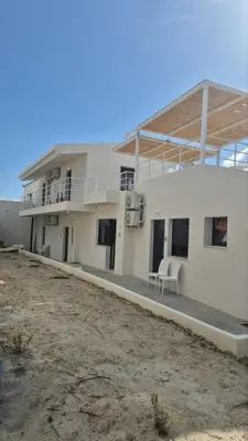 a large white building with a porch and a balcony at Aldea Apartments in Módhion