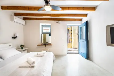a bedroom with a white bed and a blue door at Amy's Little Gem in Chania Town