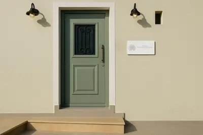 a green door on a white wall with stairs at Yalos Standard Studio - 5 mins to Elafonisi beach in Agios Padeleimon