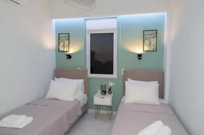 a bedroom with two beds and a mirror at Nafsika's Cozy Apartment in Chania Town